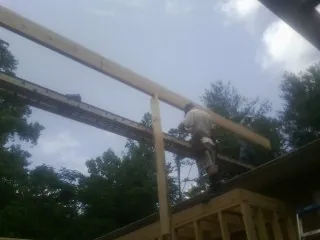 Carpenter setting a ridge beam over a new addition frame — Ice Dam Removal by Roofing Brothers in Elko New Market