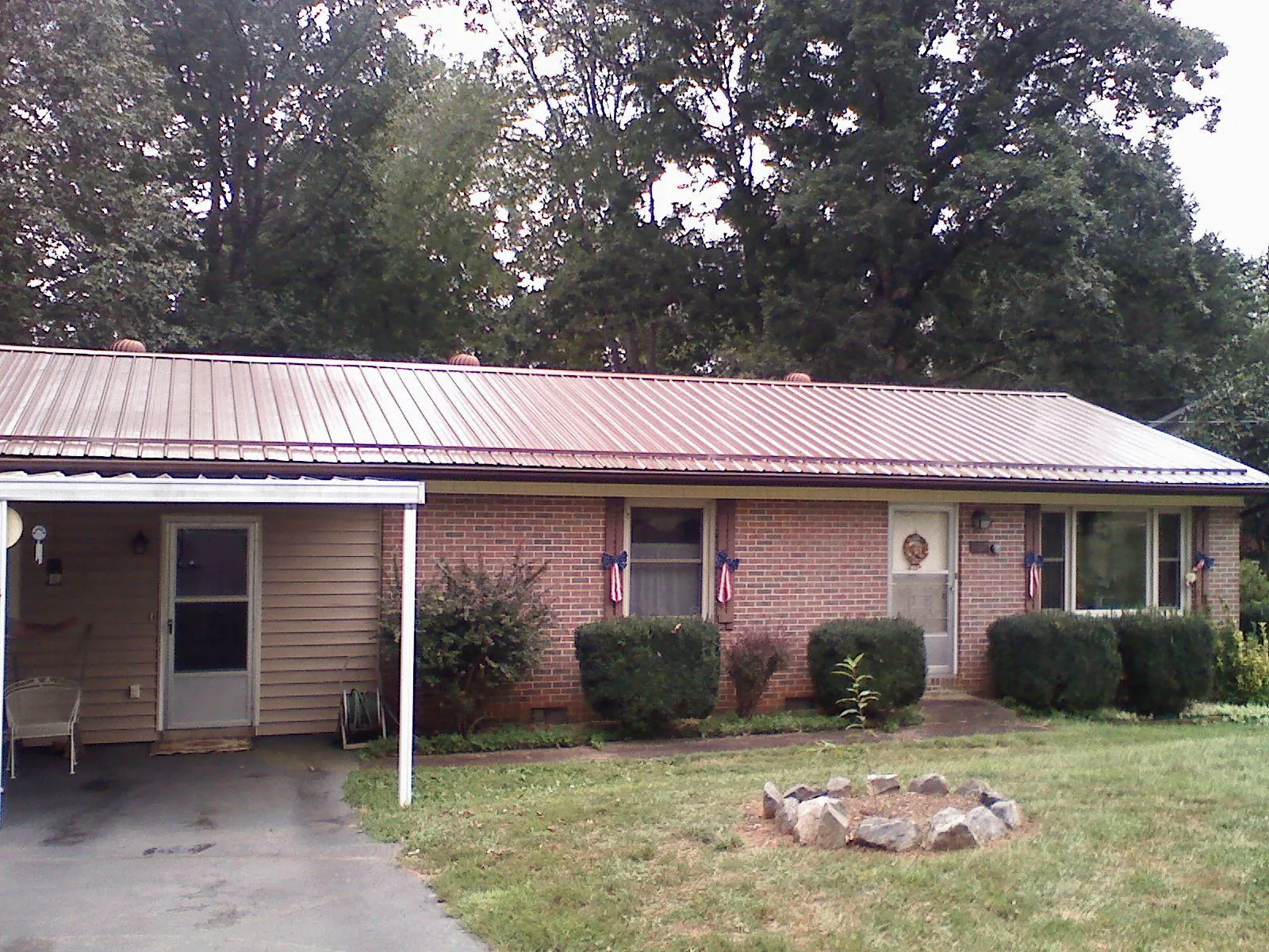 Bronze metal roof and carport on a brick ranch home — Roof Repair work by our crew in Elko New Market
